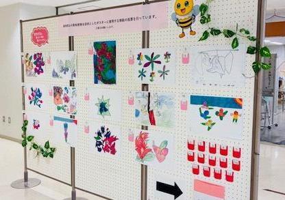 写真：創作ワークショップで作成していただいたブーゲンビレアの作品を掲示し、虐待防止の周知啓発を目的としたポスターに使用する挿絵の投票を行っています。